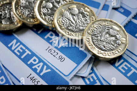 PAYSLIPS WITH ONE POUND COINS RE WAGES INCOMES PENSIONS SALARY INFLATION FINANCIAL PLANNING BREXIT HOUSEHOLD BUDGETS LIVING WAGE NET JOBS MINIMUM UK Stock Photo
