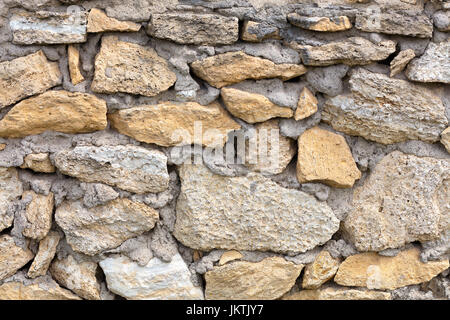 Stone wall of old limestone stones. Abstract texture Stock Photo