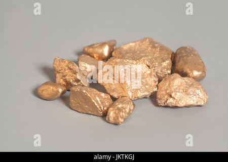 Golden nuggets on gray background Stock Photo