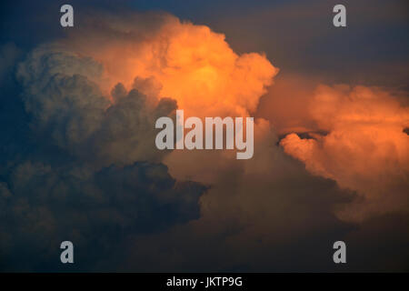 Distant thunderheads over Dallas Texas have an orange glow due to the setting sun. Stock Photo