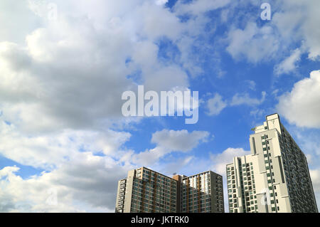 Fluffy white clouds and vibrant blue sky over the high buildings in Bangkok, Thailand Stock Photo