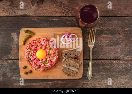 Steak tartare with garnish, red wine, and copyspace Stock Photo