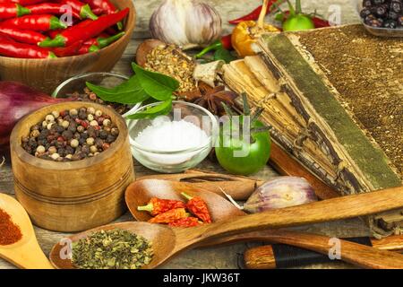 Old book of cookery recipes. Culinary background and recipe book with various spices on wooden table Stock Photo