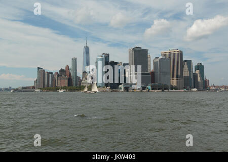 A photograph of Manhattan skyline, as seen from Governor's Island, New York City. An old sailing ship can be seen in the foreground. Stock Photo