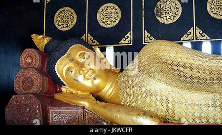 Golden reclining Buddha image statue in Thai temple in Chiang Mai, Thailand. Stock Photo