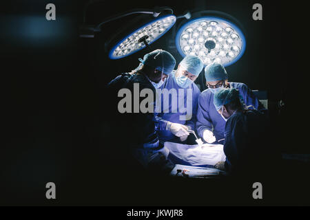 Group of surgeons in hospital operating theater. Medical team performing surgery in operation room. Stock Photo