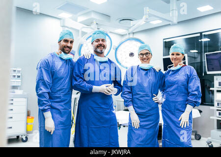 Portrait of successful team of surgeon standing in operating room, ready to work on a patient. Medical workers in surgical uniform in operation theate Stock Photo