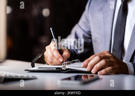 Unrecognizable businessman in the office working at night. Stock Photo