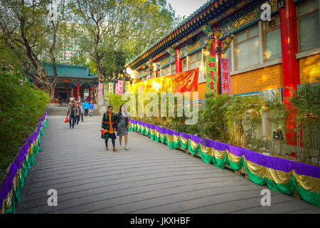 HONG KONG, CHINA - JANUARY 22, 2017: Unidentified people walking through the enter of Wong Tai Sin Buddhist Temple to pray, in Hong Kong, China Stock Photo