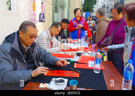 HONG KONG, CHINA - JANUARY 26, 2017: Unidentified people writting wisshes over a red paper contain meaning for Chinese New Year wishes in Hong Kong Stock Photo