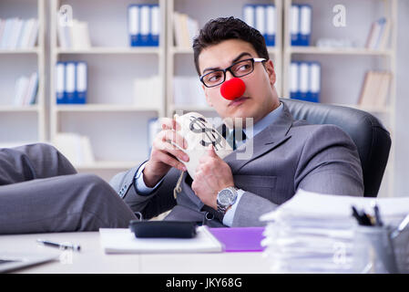 Clown businessman in the office with the a money sack Stock Photo