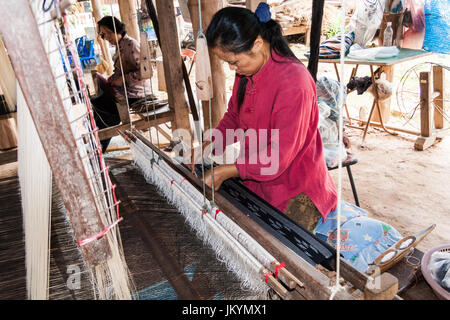 Thai ladies weaving cloth under a house in Nan,Isaan, Northern Thailand Stock Photo