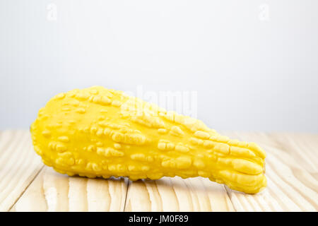 A decorative pumpkin (Yellow Crookneck) lying on wood with background for a text Stock Photo