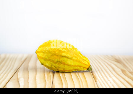 A decorative pumpkin (sweet dumpling) lying on wood with background for a text Stock Photo