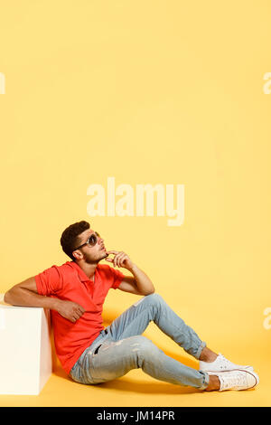 Handsome guy sitting on floor looking up Stock Photo