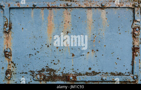Old blue rusted metal plate with rivets Stock Photo