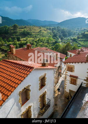 Small spanish village in the moutains. White houses in front, vineyards in background. Sunset in rain. Pobla De Benifassar, Valenciana, Spain Stock Photo