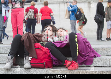 London UK. 25th July 2017. Tourists feeling the cold cover themselves in blankets in Trafalgar Square as rain and cold weather front is forecast in London Credit: amer ghazzal/Alamy Live News Stock Photo