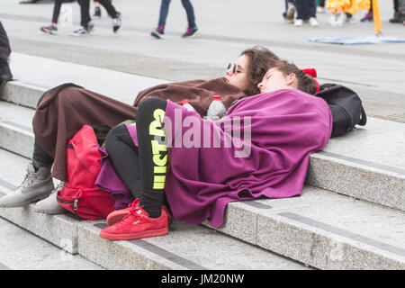 London UK. 25th July 2017. Tourists feeling the cold cover themselves in blankets in Trafalgar Square as rain and cold weather front is forecast in London Credit: amer ghazzal/Alamy Live News Stock Photo