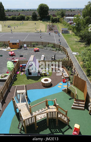Outside play area at a new primary school in London UK. Shows elevated climbing equipment, play house and coloured surfaces. Stock Photo