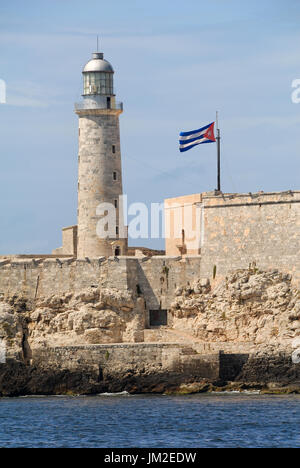 The old lighthouse and fortress called El Morro in Havana's harbor in Cuba. Shot in the daytime with a Cuban flag is flying proud next to it. Stock Photo