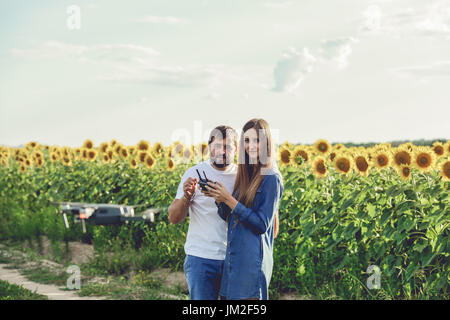 Young man operating of flying drone octocopter at the green field. Stock Photo