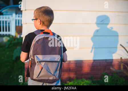 A student wearing a back pack or book bag and ready for school. Stock Photo