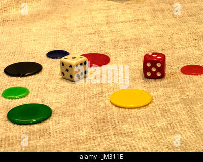 Two dice and seven counter lying on a table Stock Photo