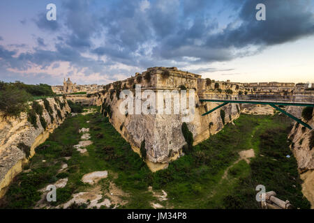 Manoel Island, Malta - Abandoned limestone fortress at the center of Manoel Island with Saint Paul's Cathedral and Valletta at the background Stock Photo