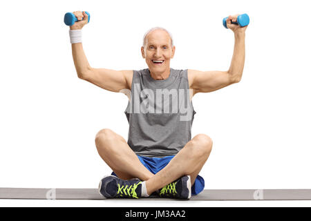Senior exercising with small dumbbells on an exercise mat isolated on white background Stock Photo