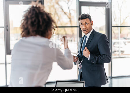 Angry businesswoman pointing with finger at frustrated young businessman Stock Photo