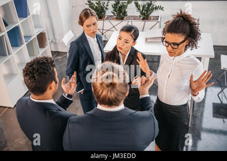 young coworkers in formalwear arguing at business meeting in office, business team meeting Stock Photo