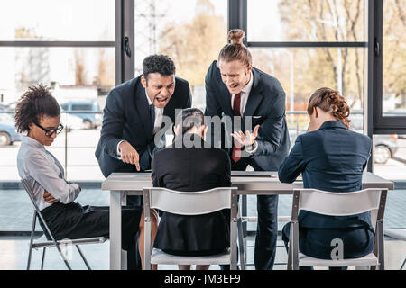 young emotional businesspeople in formalwear arguing at meeting in office, business team meeting Stock Photo