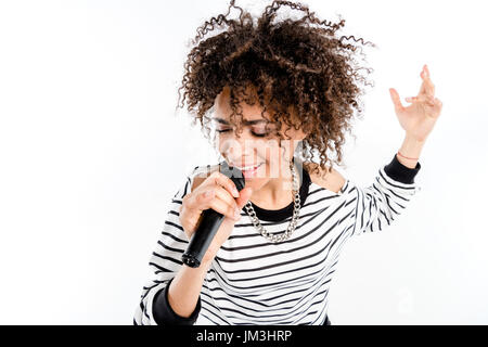 Beautiful young heavy metal singer with microphone singing and gesturing isolated on white Stock Photo