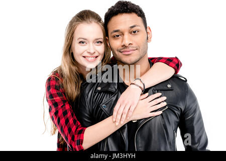 Smiling young woman hugging handsome man in leather jacket isolated on white Stock Photo