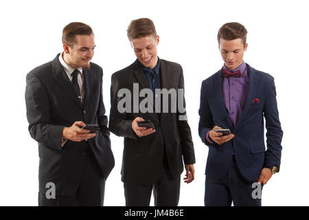 Three men in suits using their smartphones Stock Photo