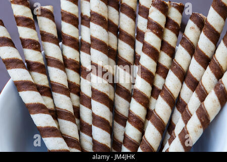 Waffle rolls with cacao and chocolate. Fresh biscuits with chocolate. Waffle rolls in red bowl Stock Photo