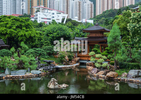 HONG KONG - JULY 18, 2014:  Nan Lian Garden. Pagoda in front of a pond in a beautiful chinese garden surrounded with exotic colors of  summer foliage. Stock Photo