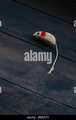 A cat's toy mouse lying on its side on a wooden floor Stock Photo