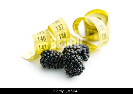Tasty ripe blackberries and measuring tape isolated on white background. Stock Photo