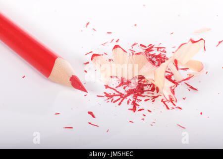 Sharpened red pencil with shavings on white background, viewed from above Stock Photo
