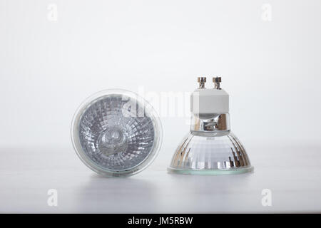 Two low voltage halogen lamps for down lights arranged showing different views in a concept of power and energy efficiency Stock Photo