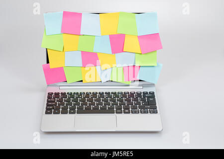 Laptop screen covered with sticky notes with different appointments on ...