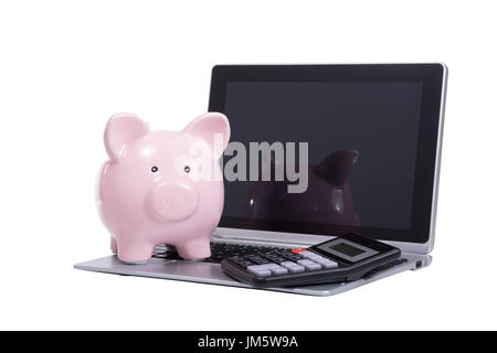 Open laptop with a calculator and piggy bank on the keyboard and a blank screen viewed low angle isolated on white with copy space Stock Photo