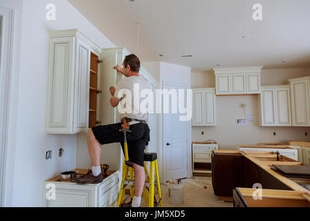 Installation Of Kitchen Worker Installs Doors To Kitchen Cabinet