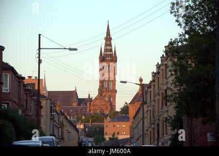 unusual view of Glasgow university from the tenement streets of the west end with a sunset on the clock tower Stock Photo