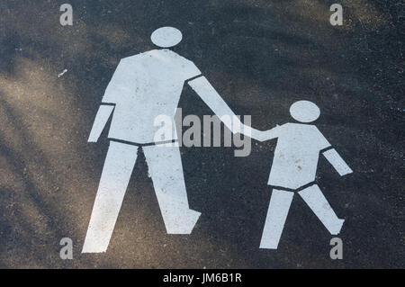 White pedestrian (adult and child) sign painted on the asphalt - indicates that it is pedestrian-only sidewalk Stock Photo