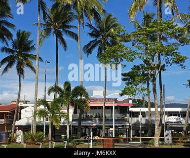 Cairns Esplanade commercial district starts across the road past the palm trees, where Iyara by Sakare Thai Restaurant is prominent upstairs Stock Photo