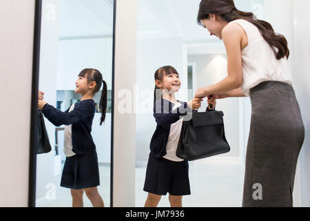 Young Chinese mother leaving for work Stock Photo
