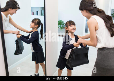 Young Chinese mother leaving for work Stock Photo